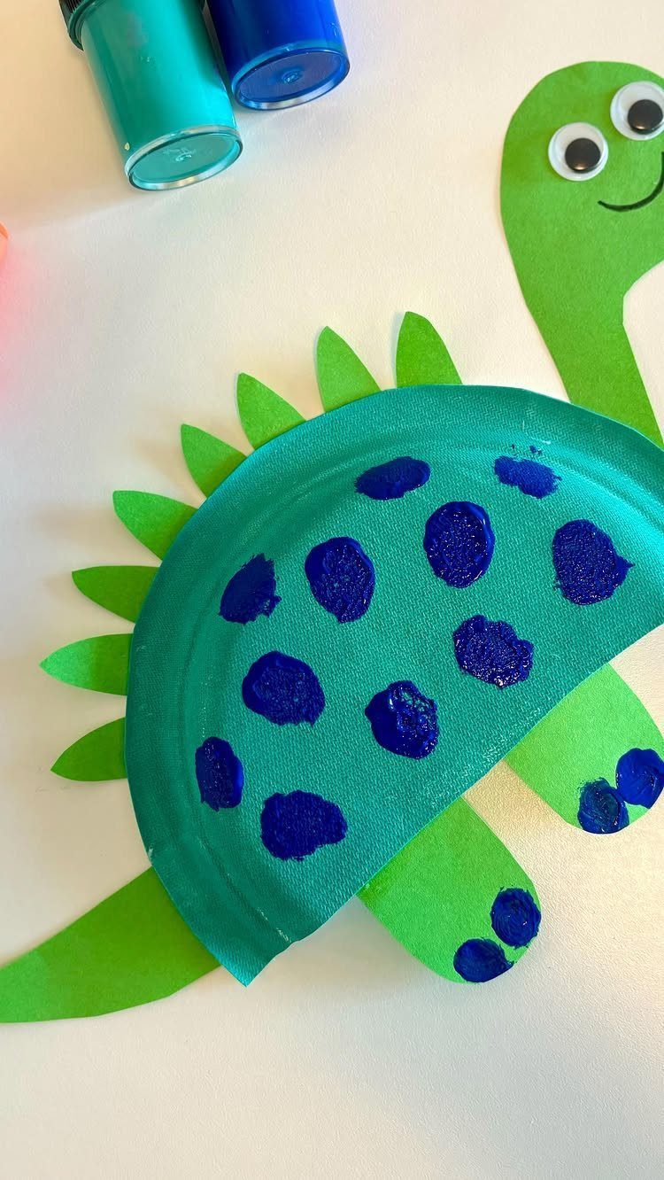 Handmade green dinosaur craft made from a paper plate and construction paper.