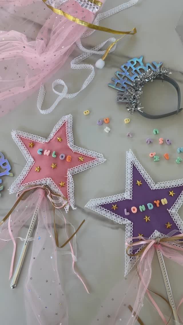 Two star-shaped wands with names and pink tulle on a light background.