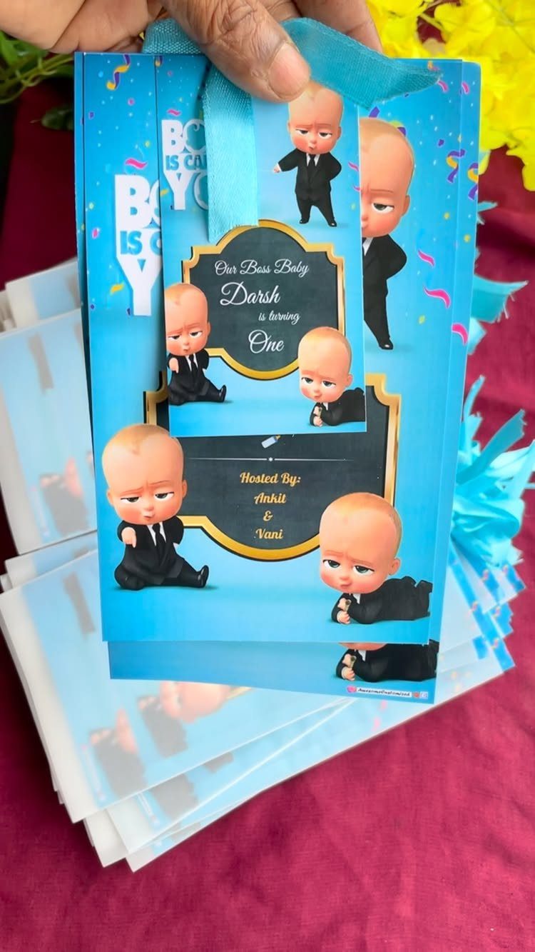 Blue first birthday invitation with cartoon babies in suits and personalized gold text.
