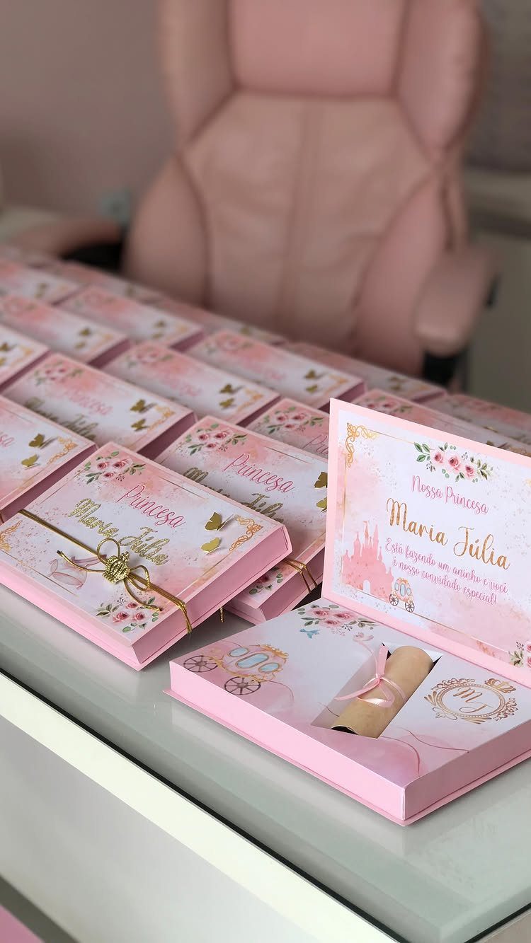 Pink princess themed invitation boxes with floral details and a rolled parchment scroll.