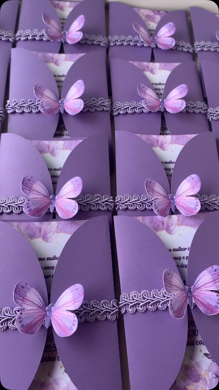 Purple folded invitation cards decorated with lace ribbons and small purple butterflies.
