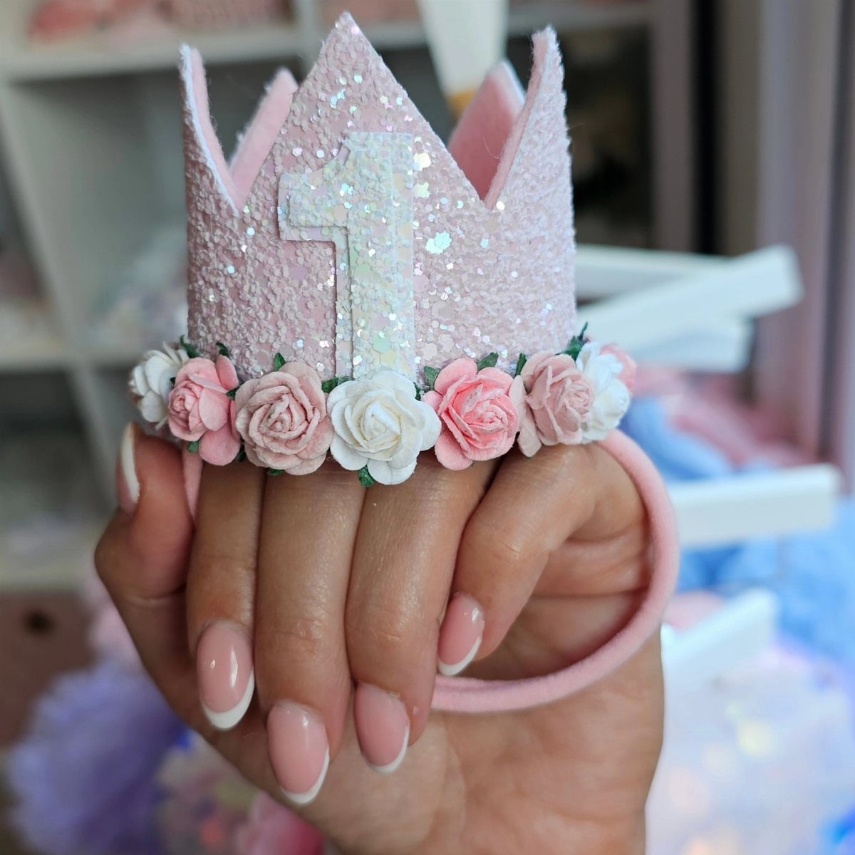 Pink glittery crown headband with white number one and small fabric roses.