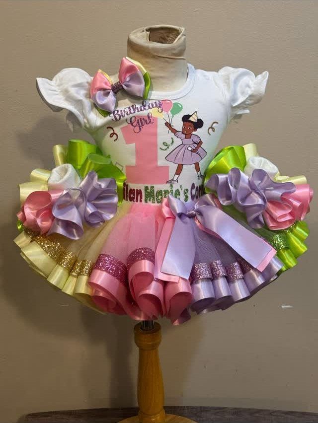 Baby girl's first birthday outfit with a graphic t-shirt and colorful tutu