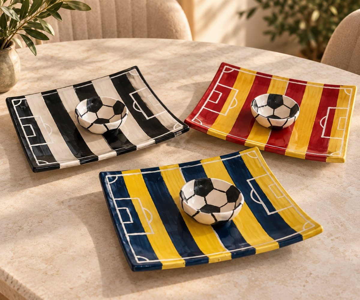Football-themed ceramic plates and bowls with pitch designs on a round table