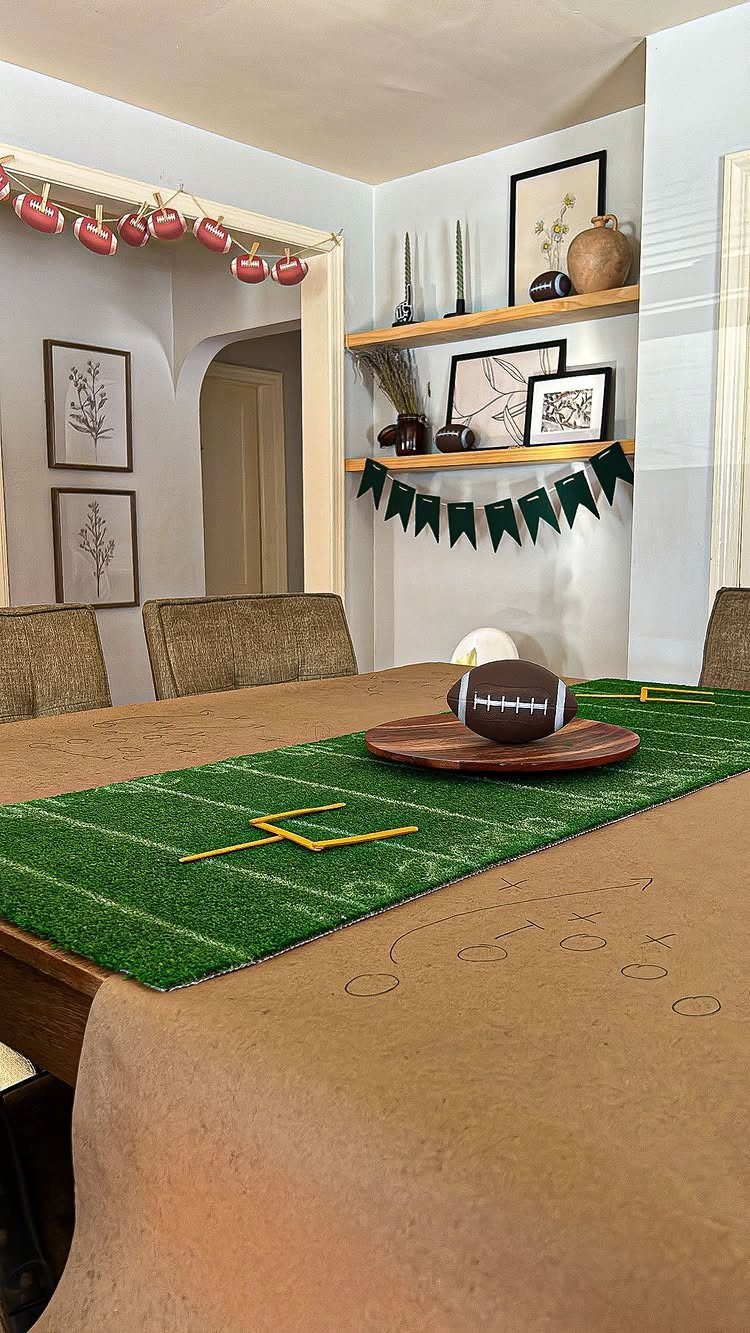 Football on a wooden platter atop a green turf table runner with goalposts.