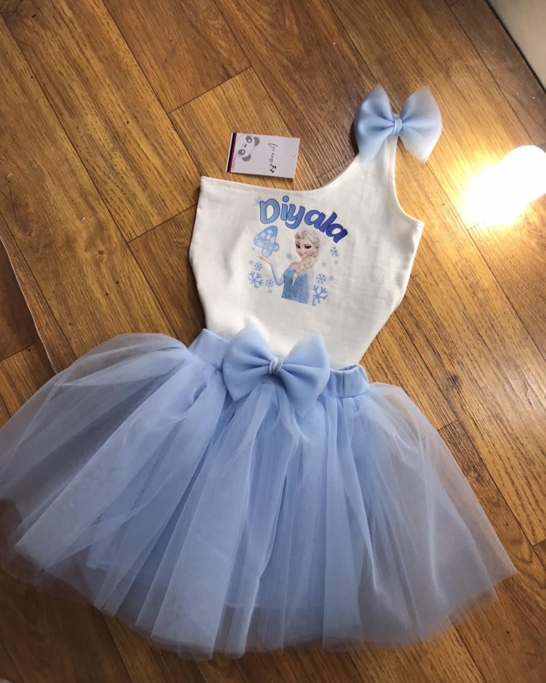 Frozen themed child's outfit with Elsa top and blue tulle tutu on wooden floor