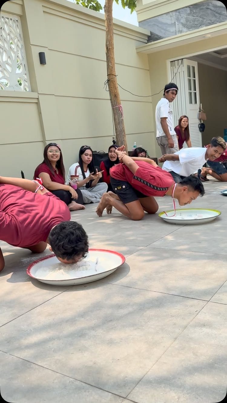 Teenagers leaning their faces into plates of white powder during a party game.