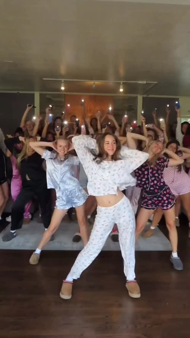 Teenage girls in pajamas dancing and posing together in a living room.