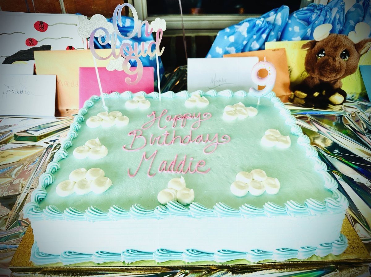 Light blue birthday cake with white clouds and pink lettering for Maddie's ninth birthday.