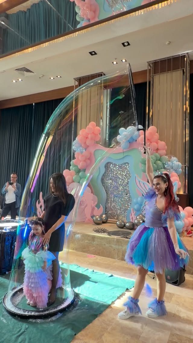 Young girl in a tutu inside a giant soap bubble at a party