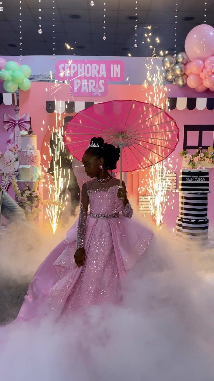 Girl in pink gown with parasol at a Sephora in Paris themed party.
