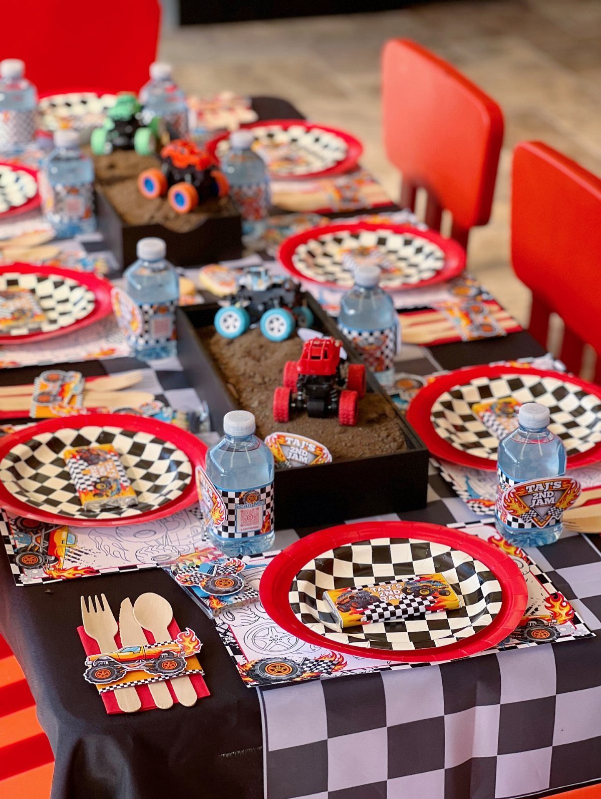 Checkered plates and cups on a monster truck themed party table setting.