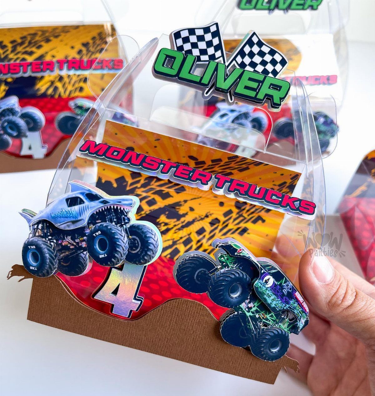 Monster truck themed party favor boxes with personalized name and age labels.