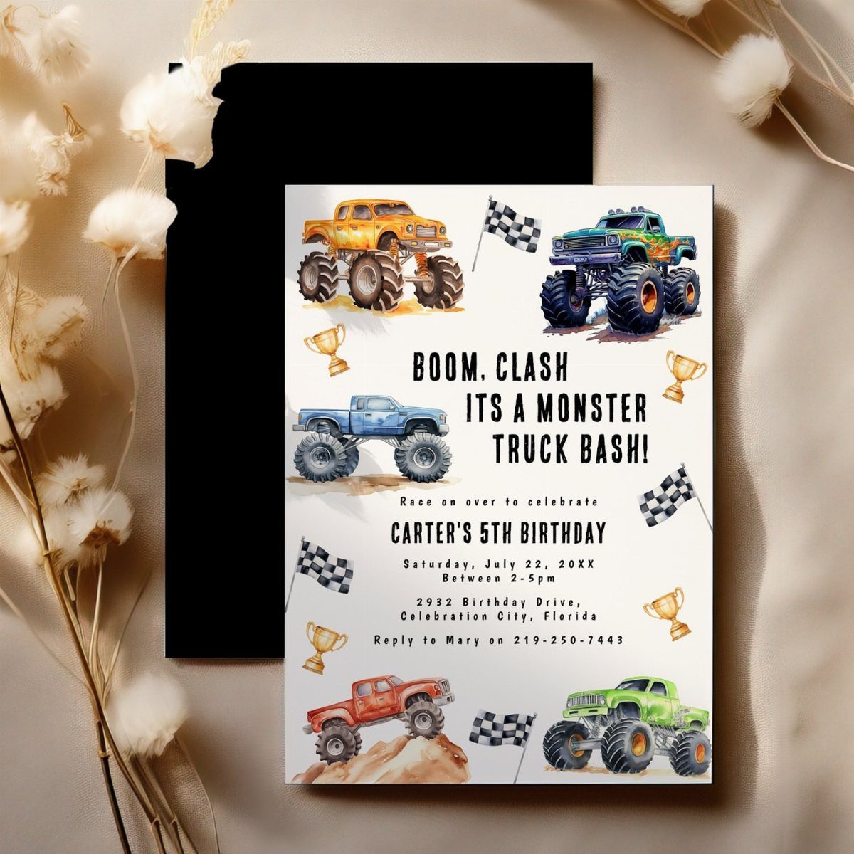 Monster truck birthday invitation card with colorful trucks and checkered flags on black envelope