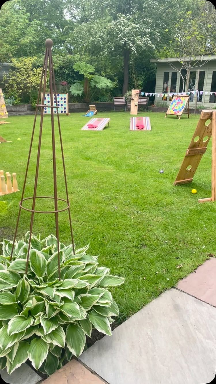 Wooden lawn games set up on a green grass backyard for a party.