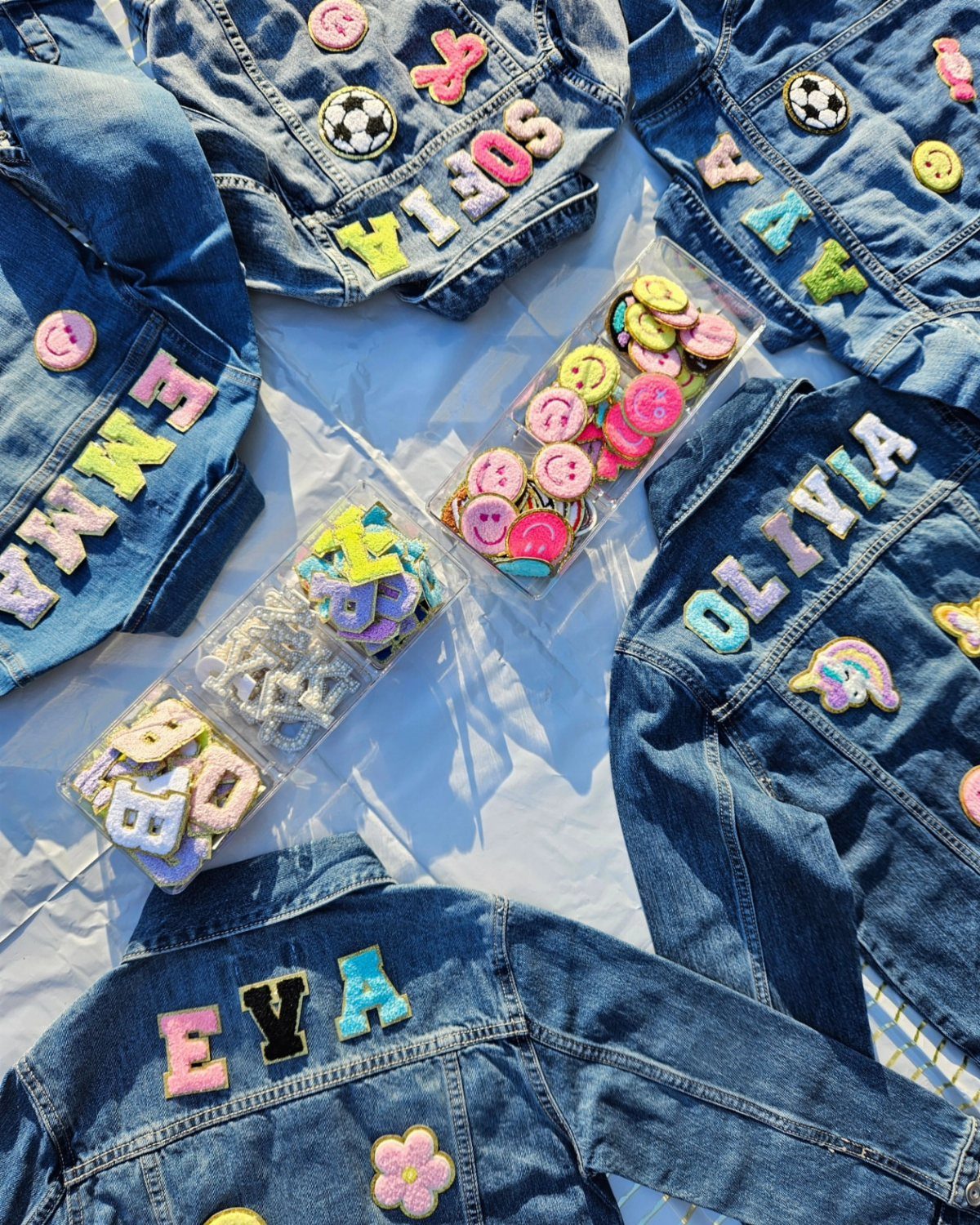 Denim jackets customized with colorful adhesive letter patches and patch organizer bins.