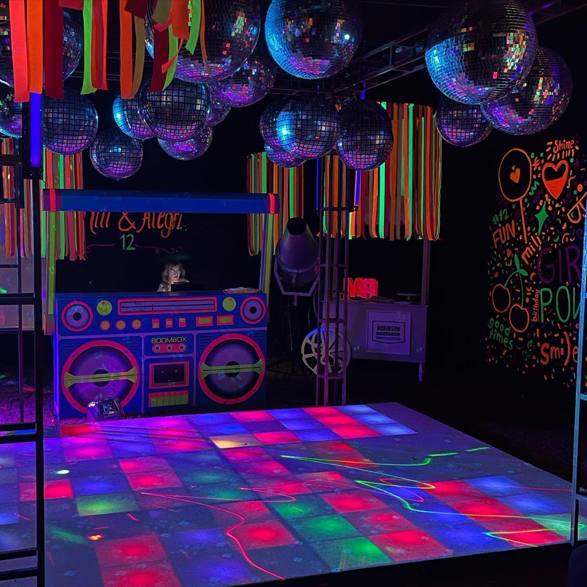Neon light-up dance floor with disco balls and a boombox DJ booth.