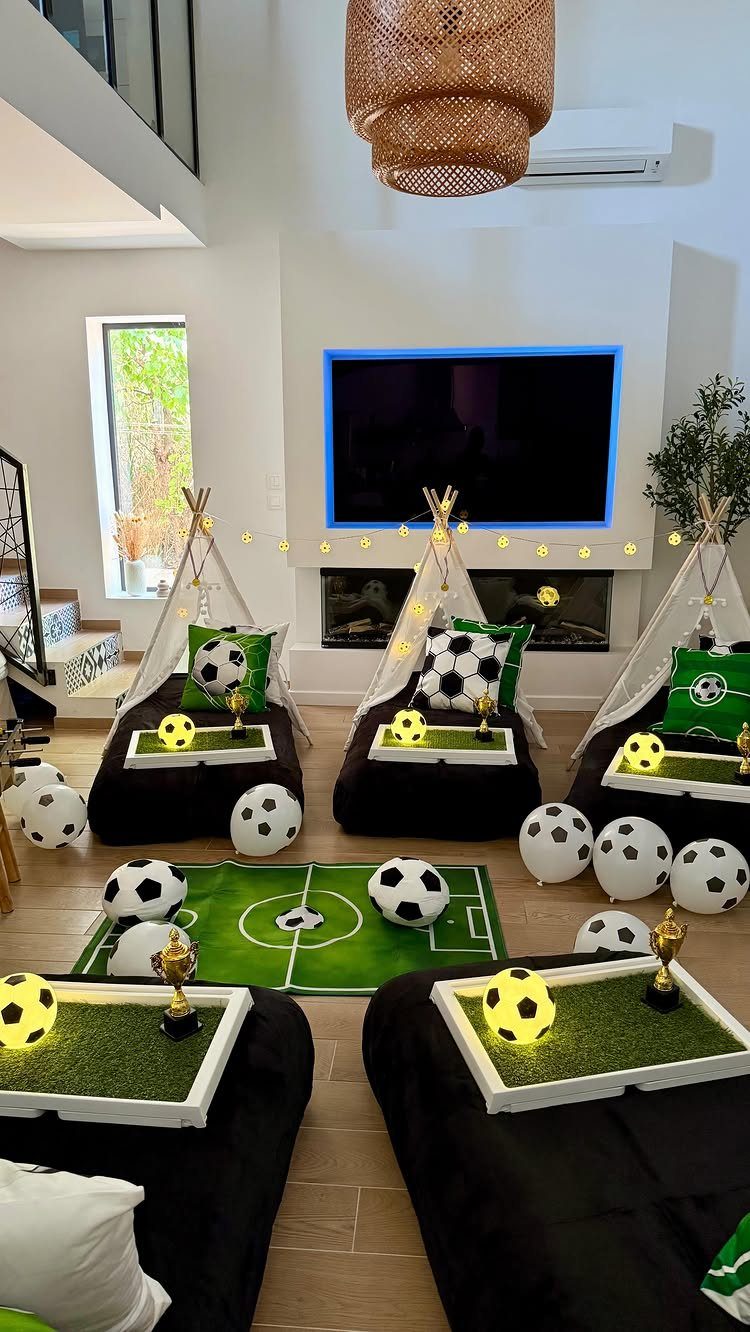 Soccer themed sleepover setup with teepees, black mattresses, and soccer ball decorations.