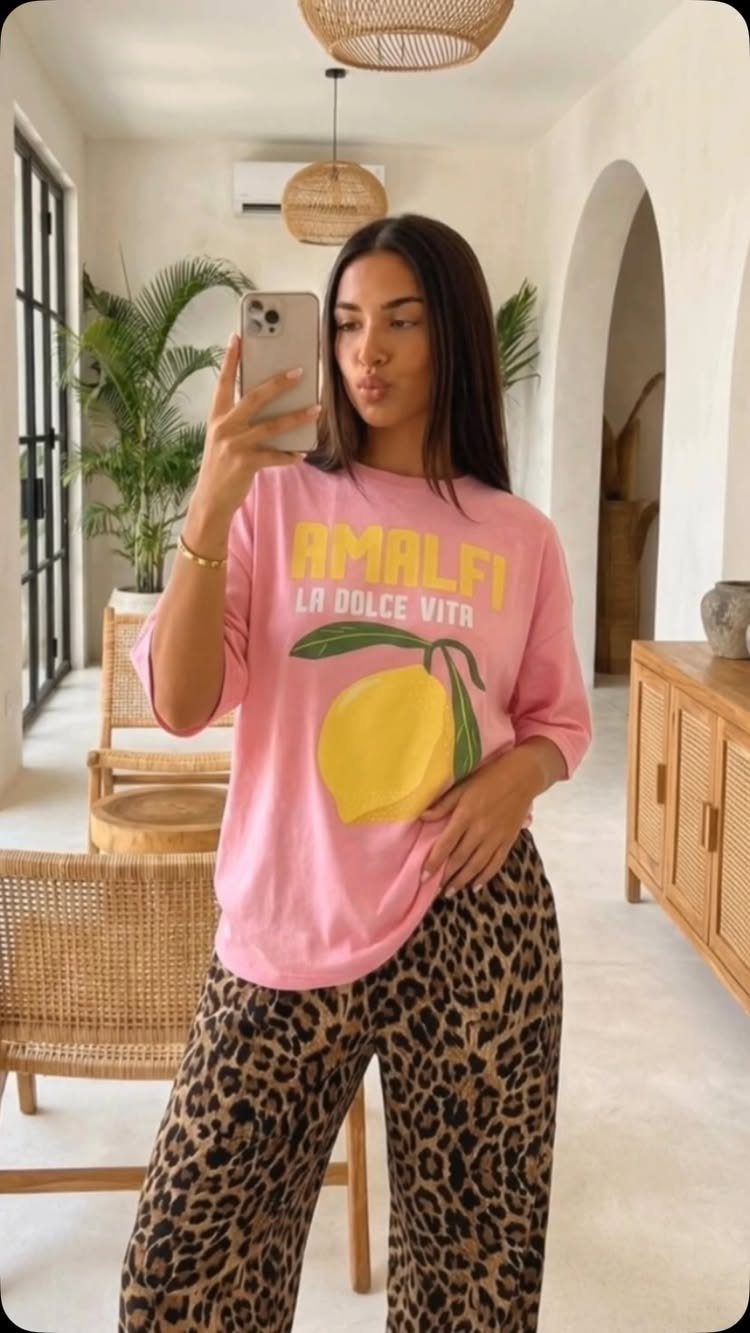 Woman wearing a pink lemon graphic tee and leopard print lounge pants.