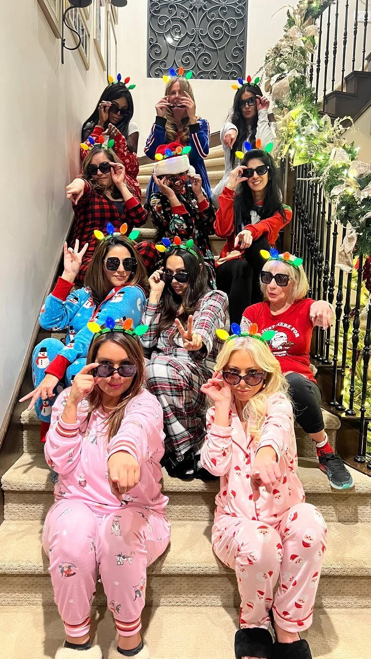 Women in pajamas and light-up headbands posing on a carpeted indoor staircase.