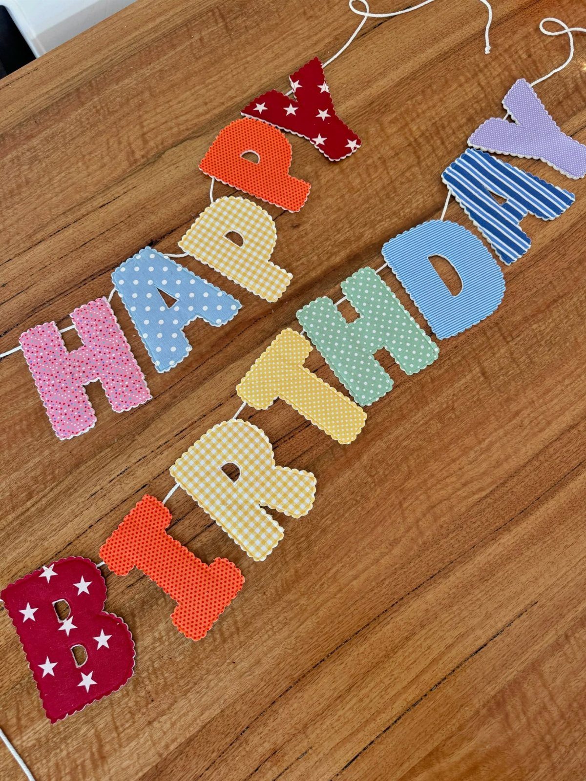 Colorful fabric Happy Birthday bunting banner with patterns on a wooden table