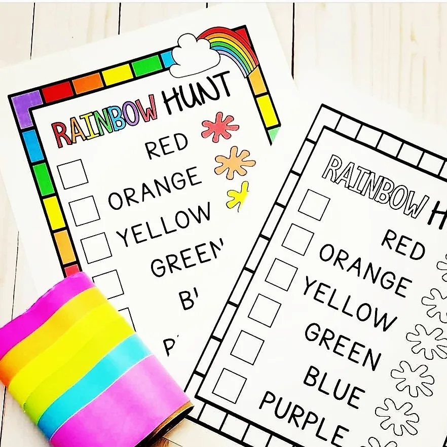Rainbow hunt checklists and colorful ribbon on a white wooden background.