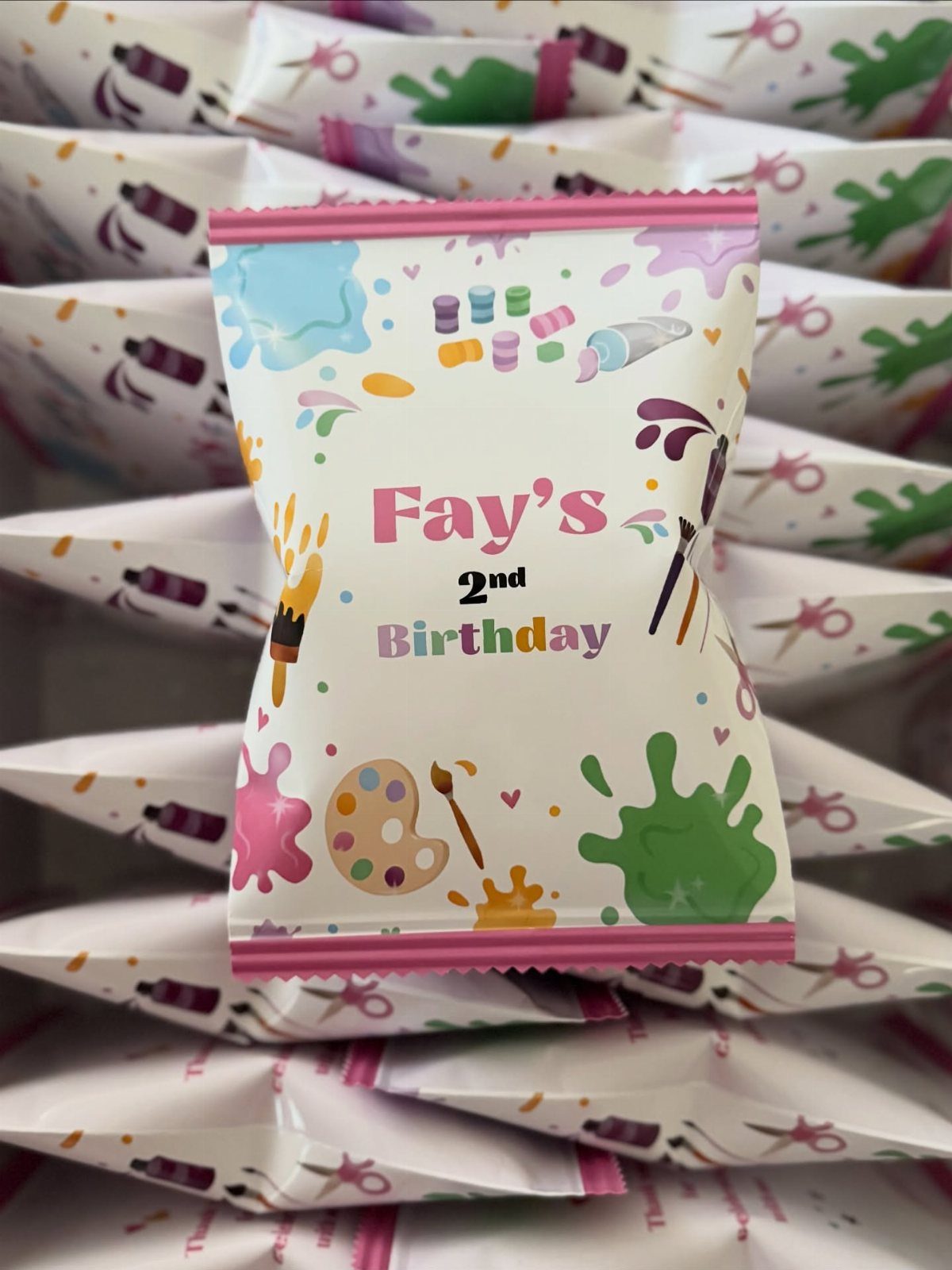 Art themed party favor bags for a second birthday with paint splatters.