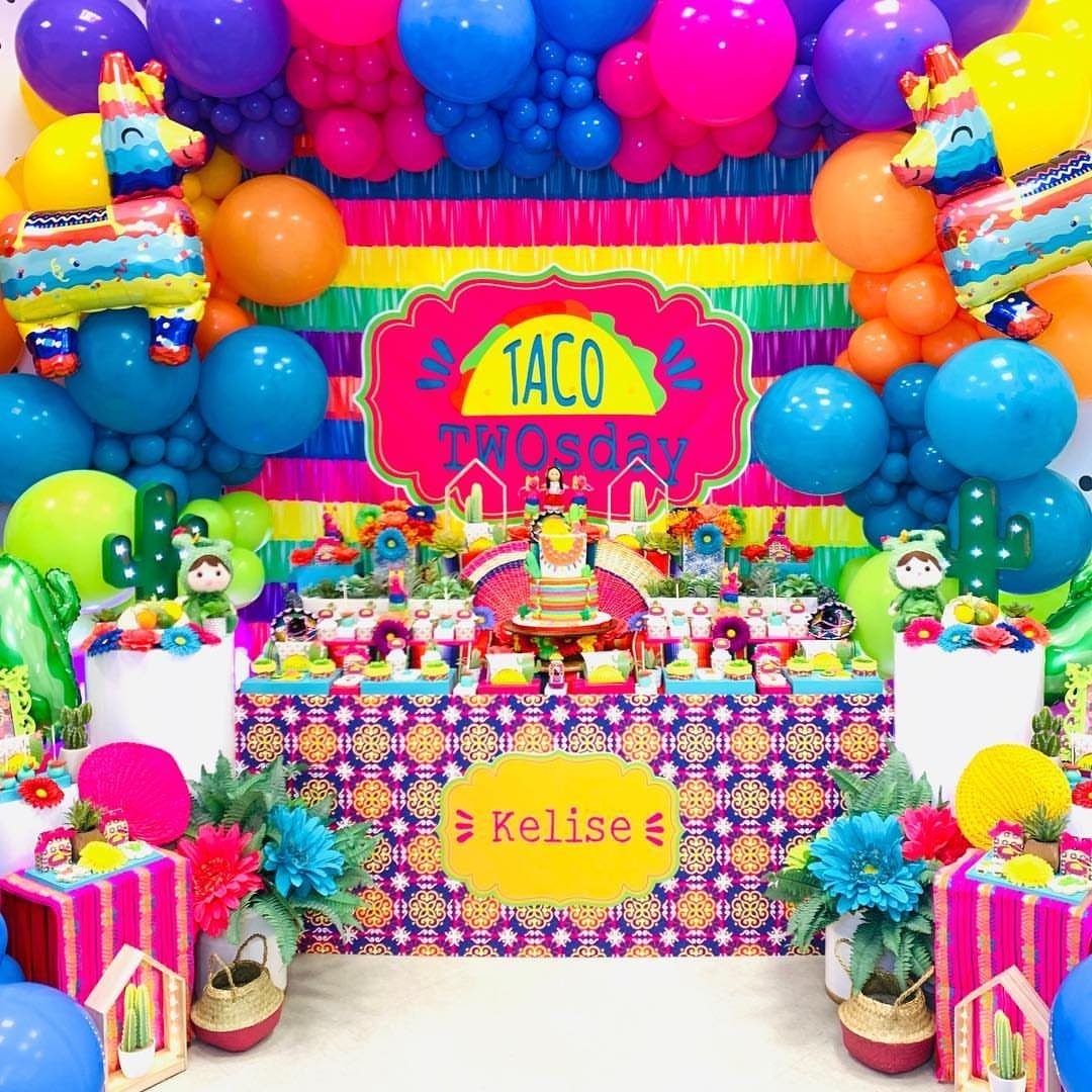 Taco TWOsday party setup with colorful balloons, piñata decorations, and a dessert table.