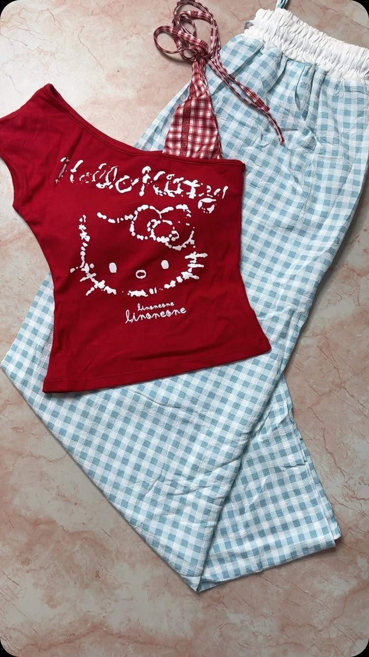 Red Hello Kitty top and blue gingham checkered pajama pants on a surface.