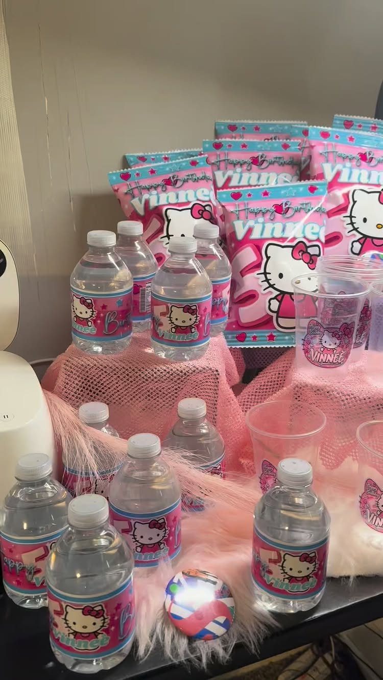 Customized water bottles and treat bags with Hello Kitty labels on pink tulle.