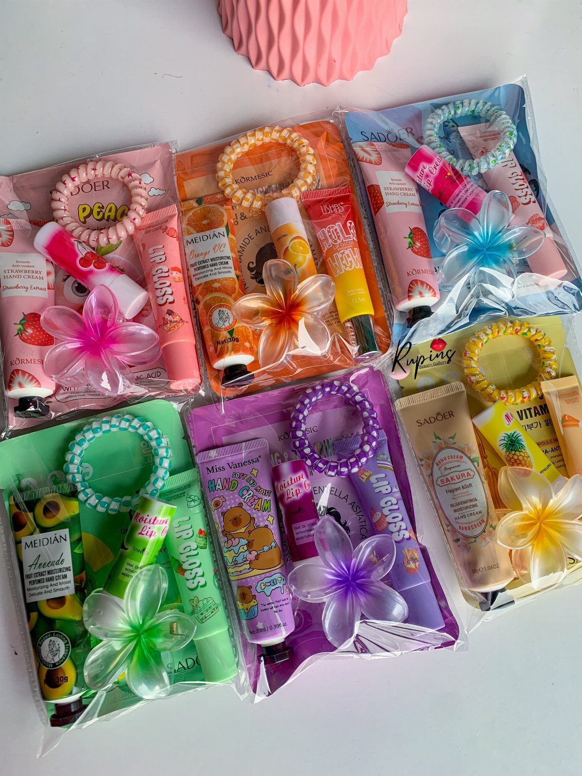 Six colorful mini self-care kits in clear bags with skincare and accessories.