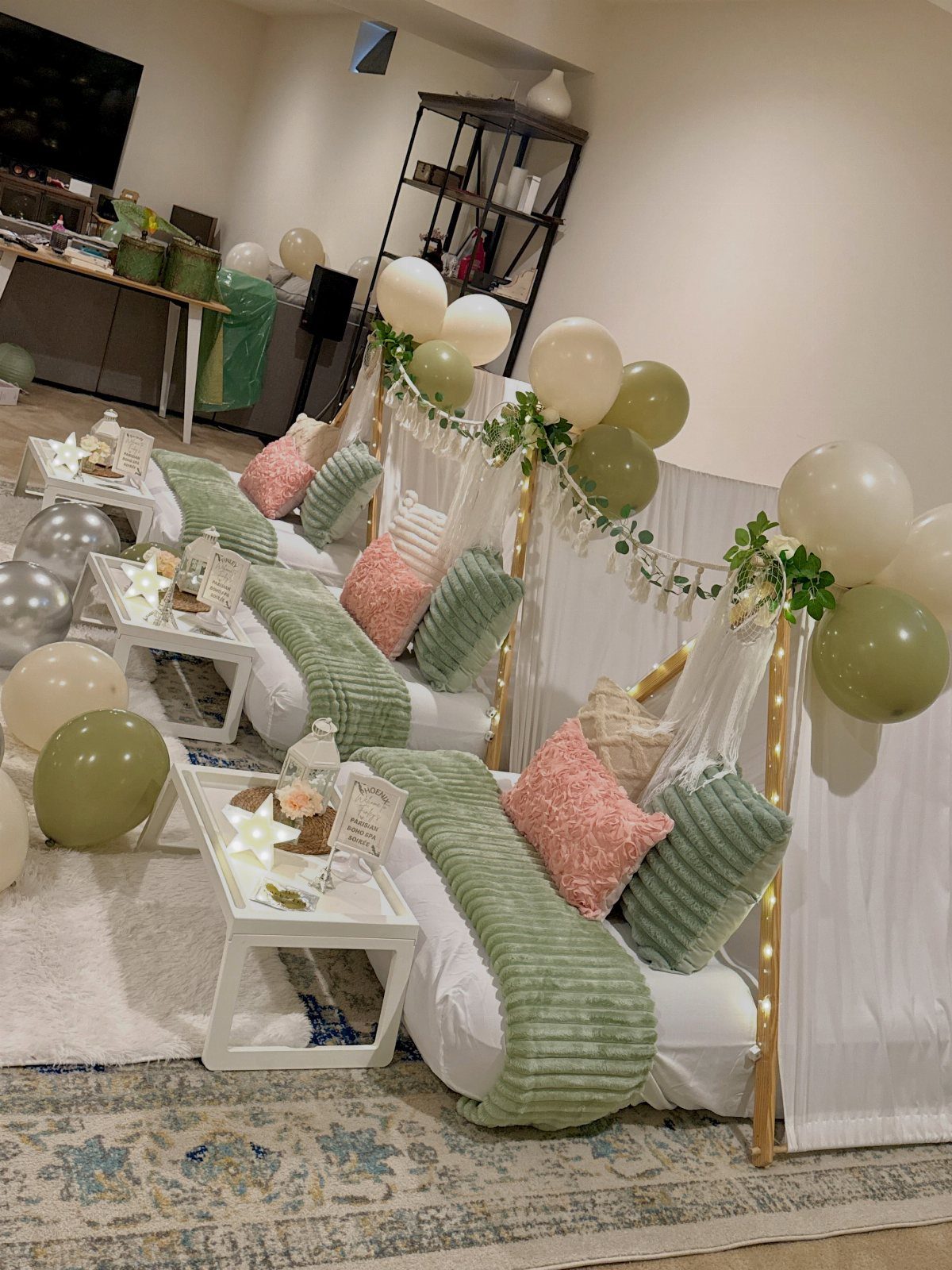 Sleepover setup with white beds, green and pink pillows, and balloon decorations.