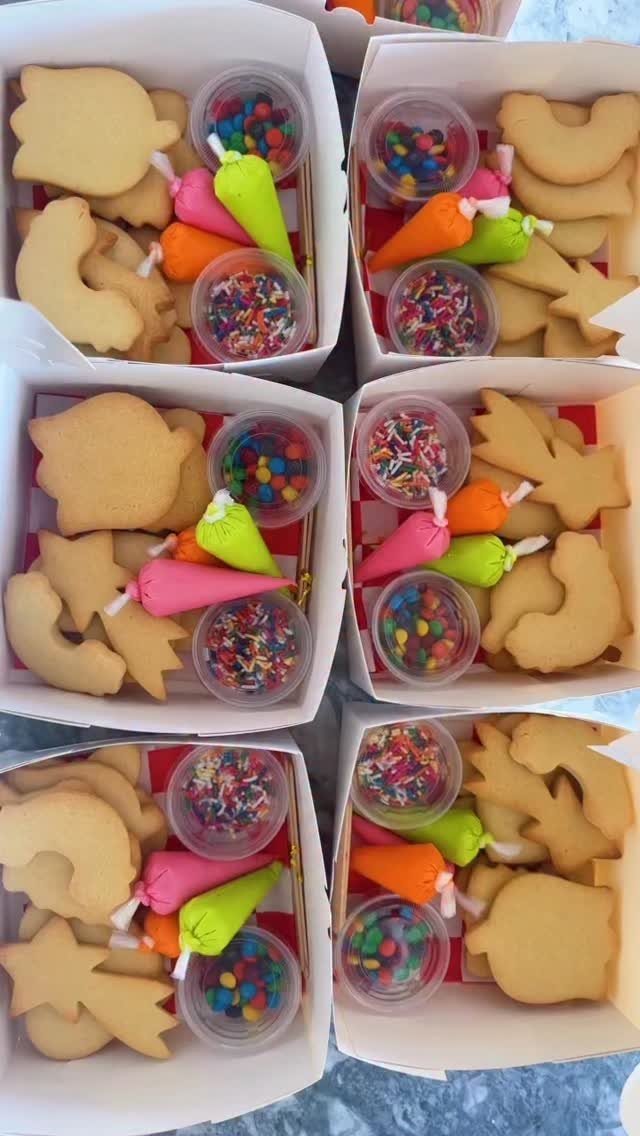 Cookie decorating kits in white boxes with frosting and colorful sprinkles
