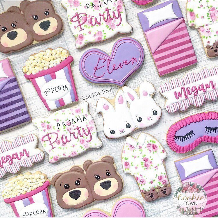 Decorated sugar cookies in shapes of beds, bears, and popcorn for a pajama party.