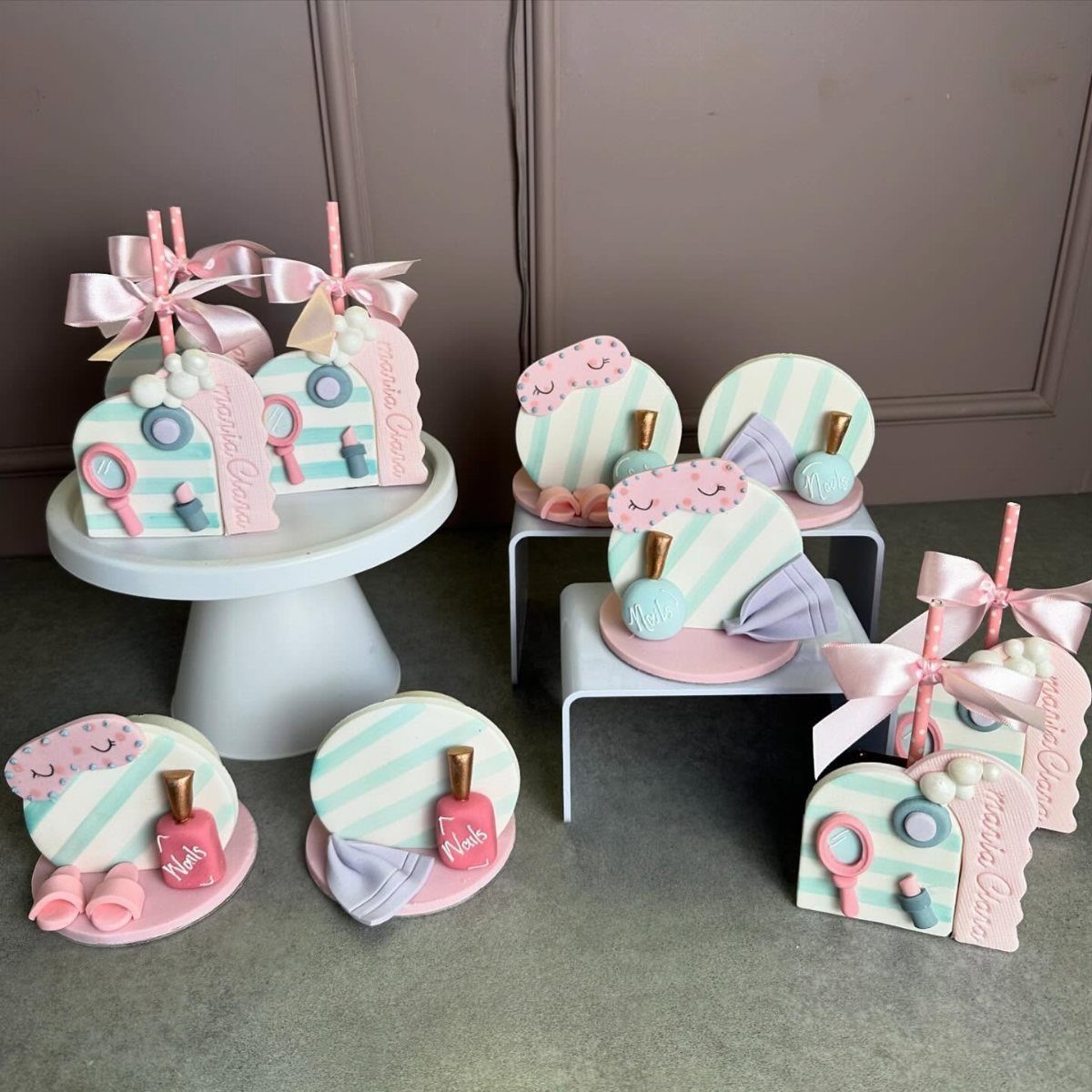 Nail polish and beauty kit shaped cookies with pink and blue stripes.