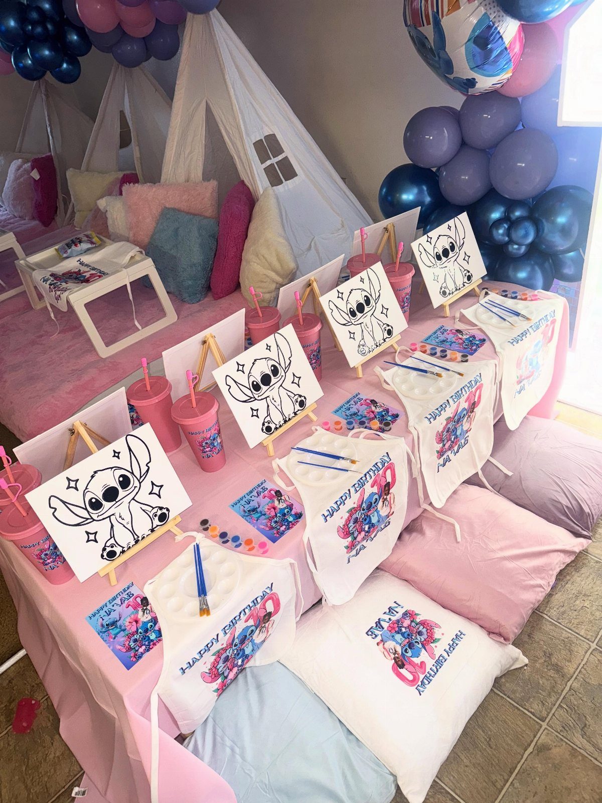 Pillowcase decorating station with Stitch drawings, markers, and teepees for a birthday party.