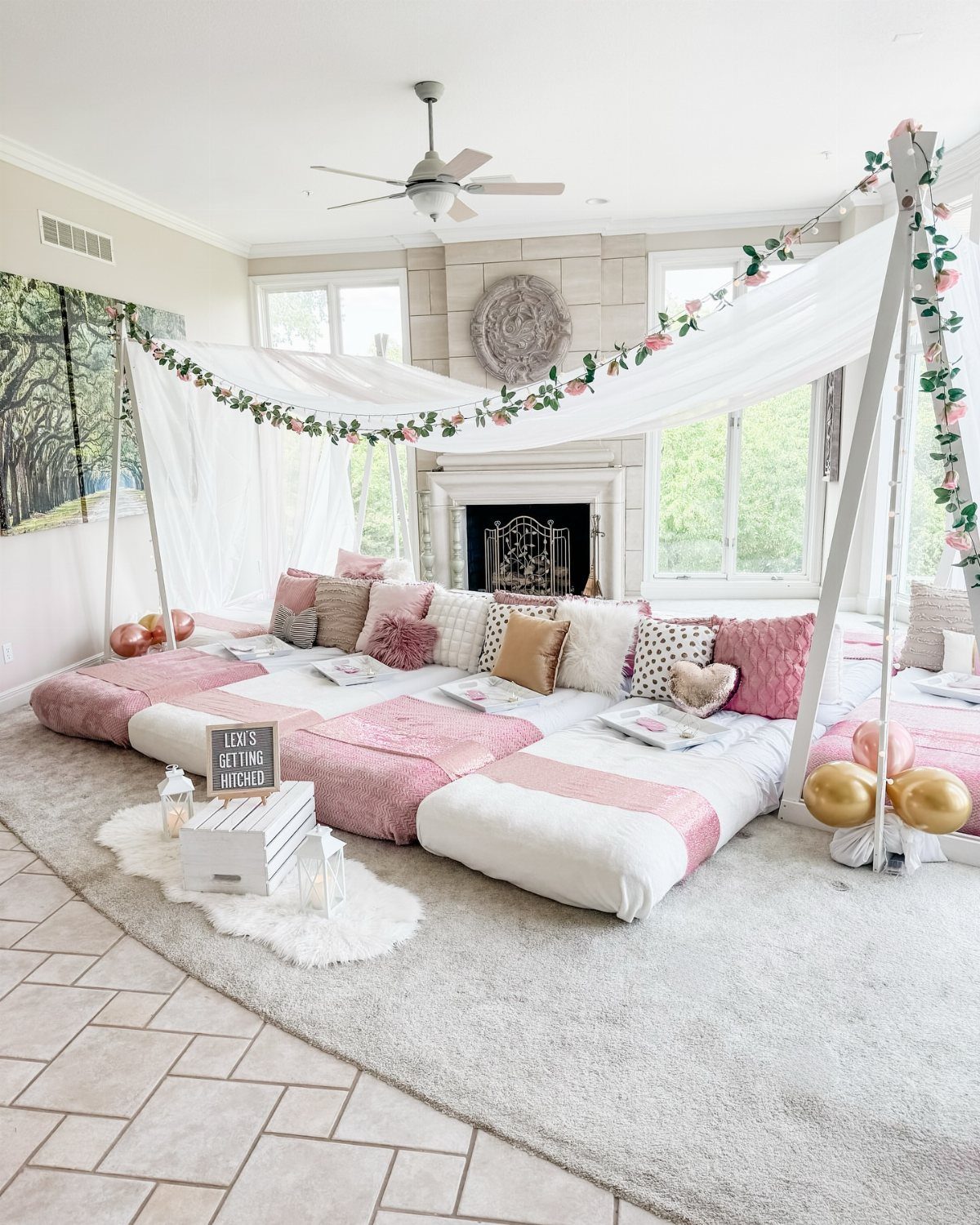 Cozy lounge area with pink and white floor mattresses under a floral canopy.