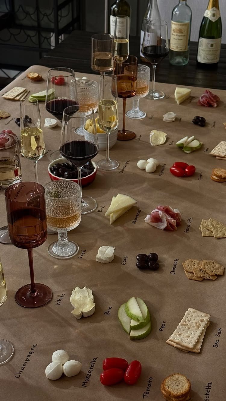 Charcuterie spread with wine glasses on brown parchment paper covering a long table