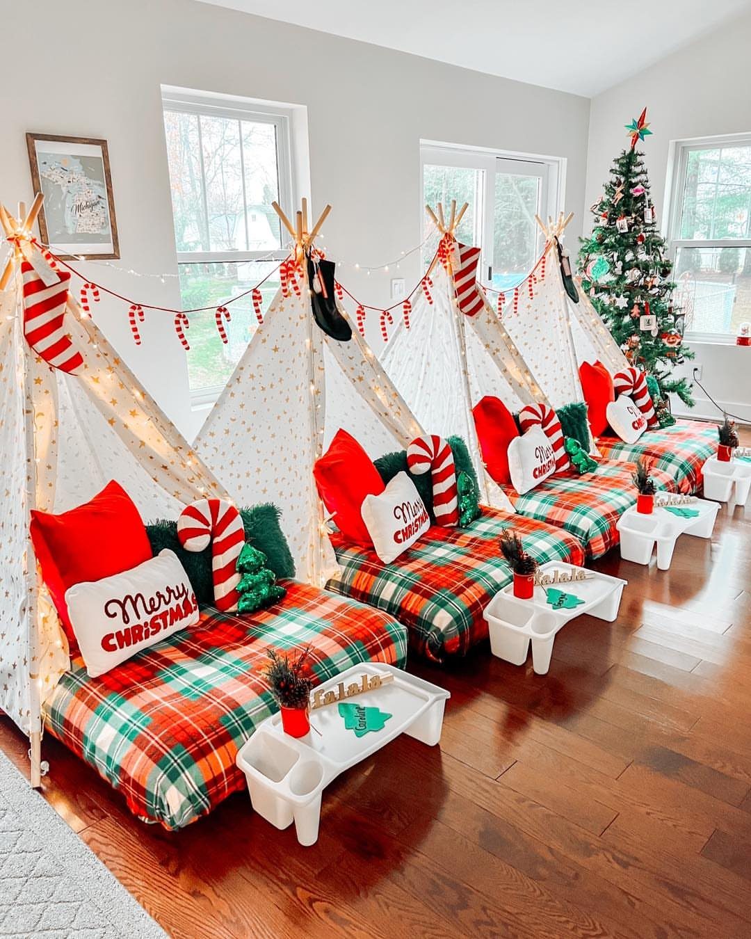 Four Christmas themed teepee tents with plaid bedding and candy cane decorations.