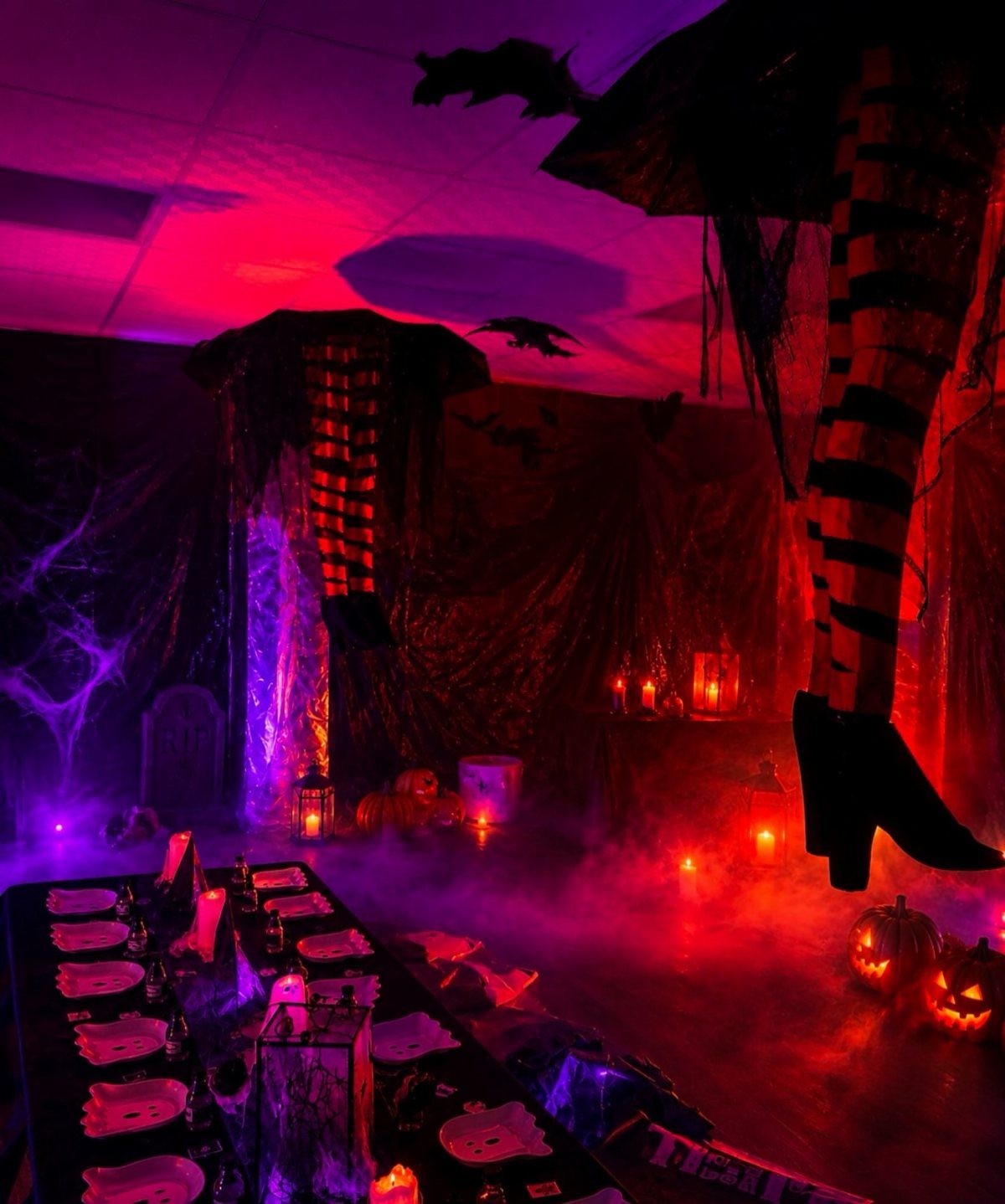 Spooky room with red and purple lighting, fog, and a hanging figure.