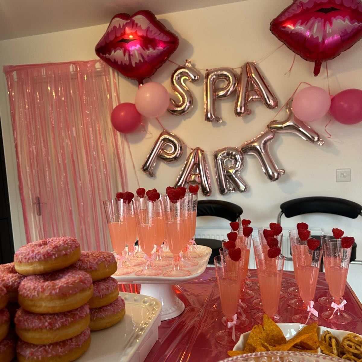 Silver foil balloons spelling SPA PARTY with red lip balloons and pink treats.