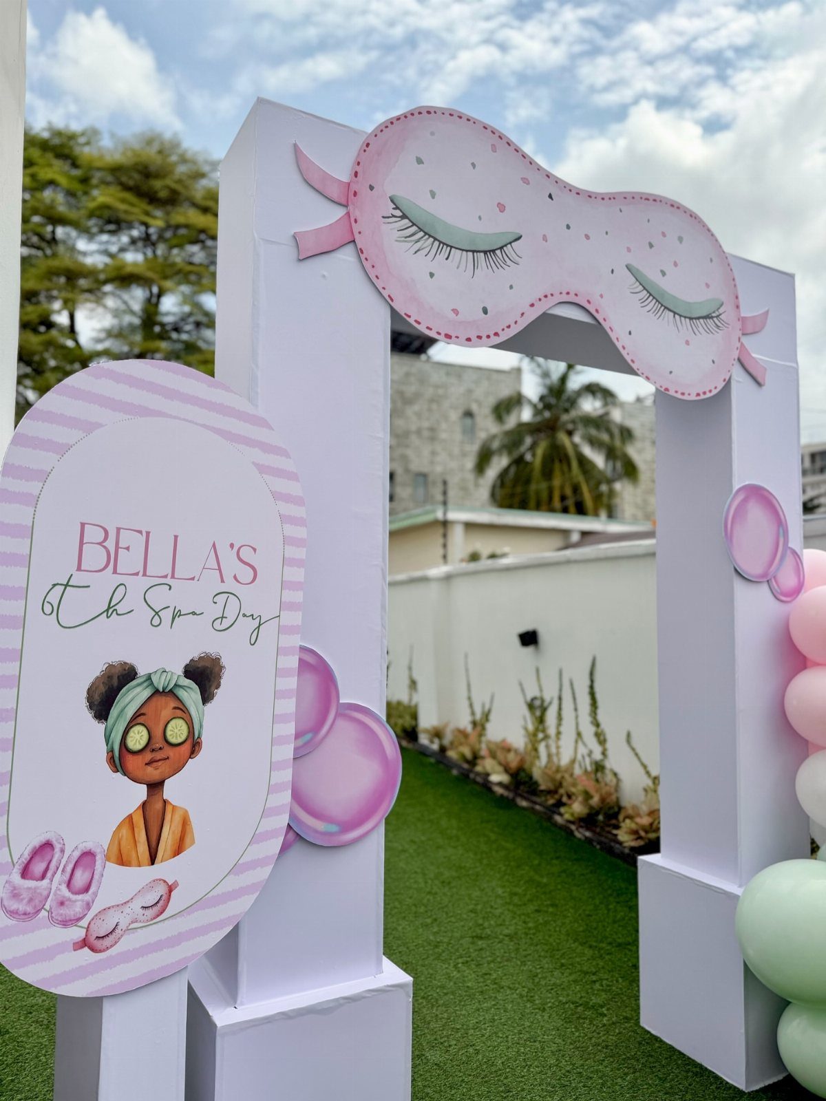 White party arch with a large pink sleep mask cutout and themed signage.