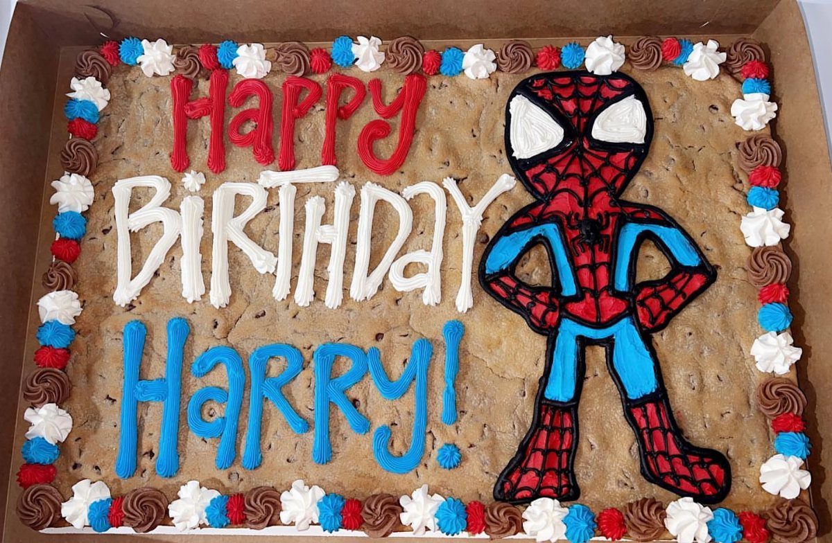 Spider-Man cookie cake with red, white, and blue frosting and birthday message.