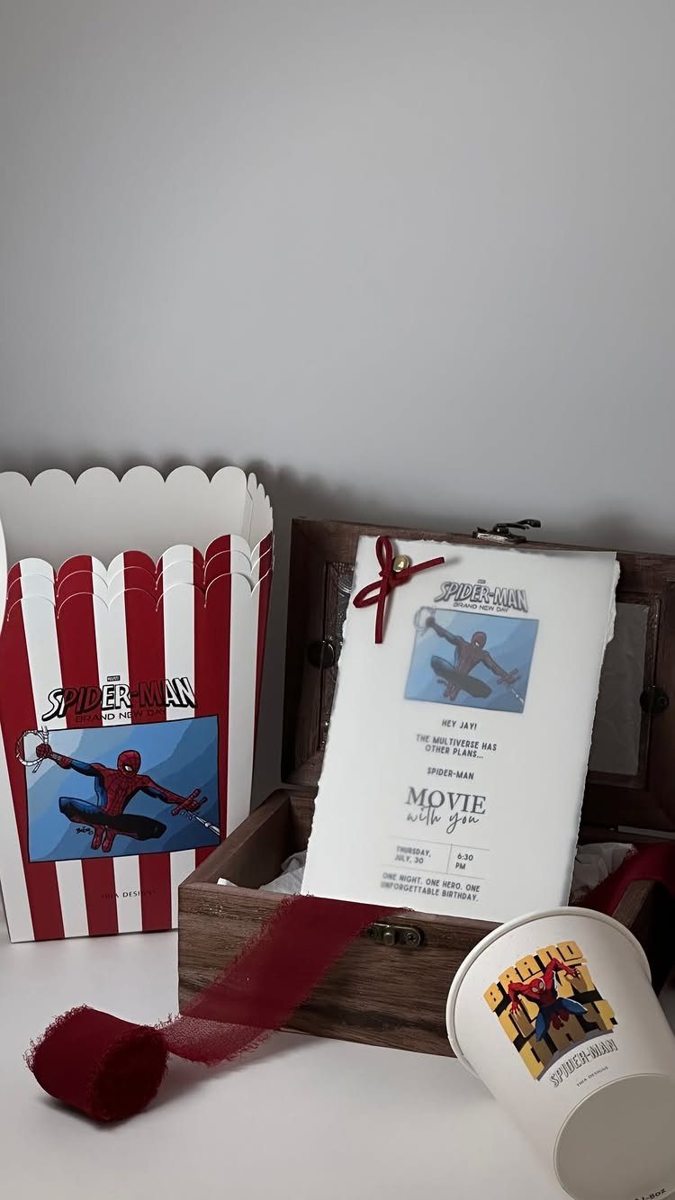Spiderman themed invitation card in a wooden box with matching party favors.