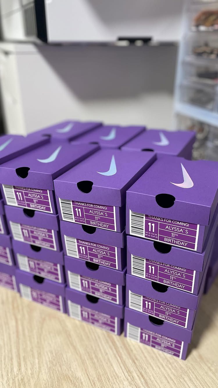 Purple Nike shoe boxes with custom 11th birthday labels stacked on a table.