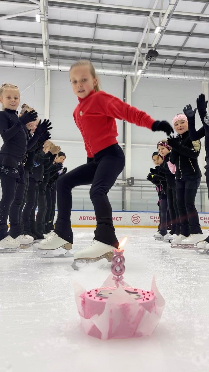 Girl ice skating on a rink with a pink birthday cake in the foreground