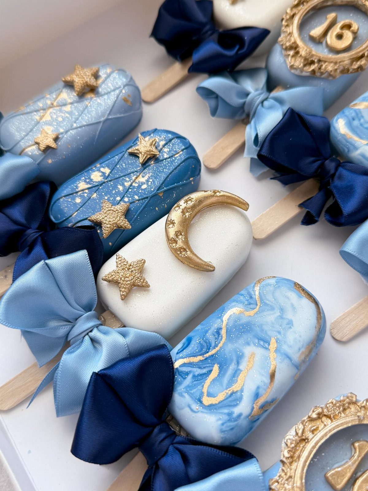 Blue and white cake pops with gold stars and the number 16.