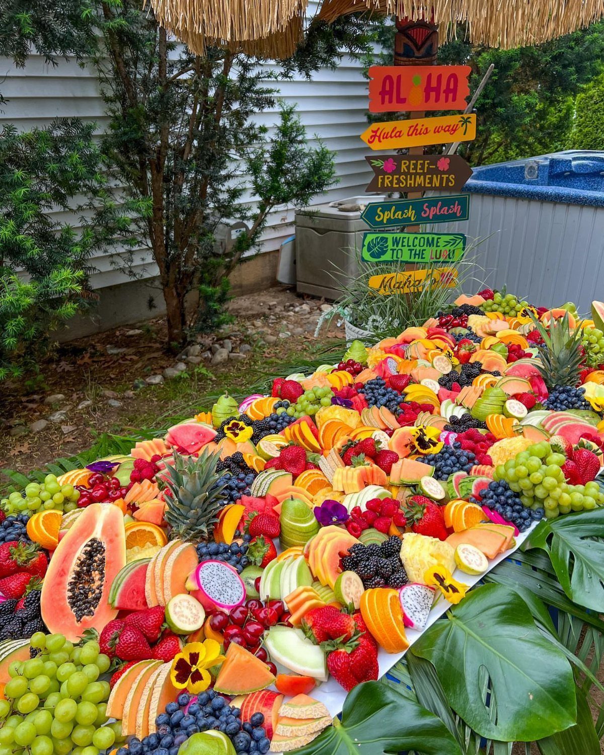 Tropical fruit platter with a Hawaiian themed signpost in an outdoor setting