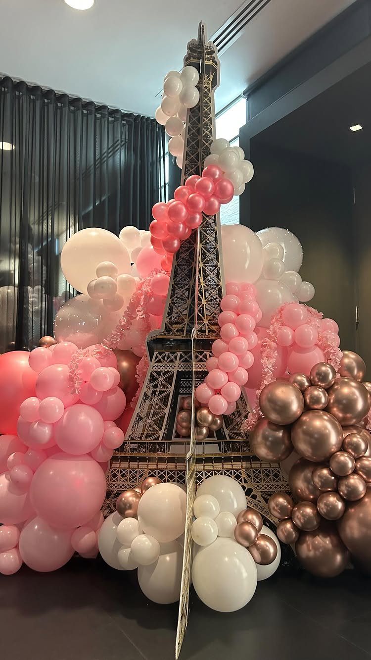 Gold Eiffel Tower model surrounded by pink, white, and rose gold balloons.