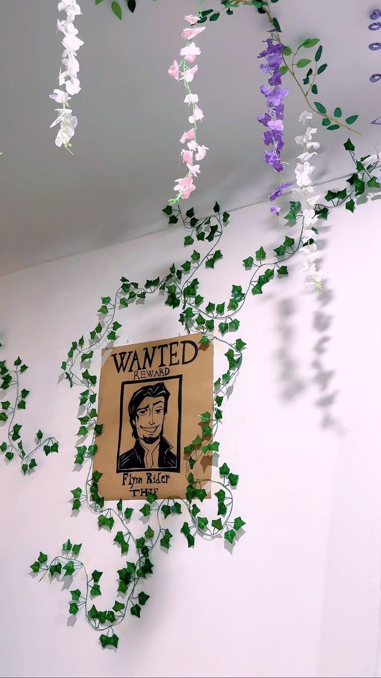 Wanted poster and ivy vines decorating a white wall for a themed party
